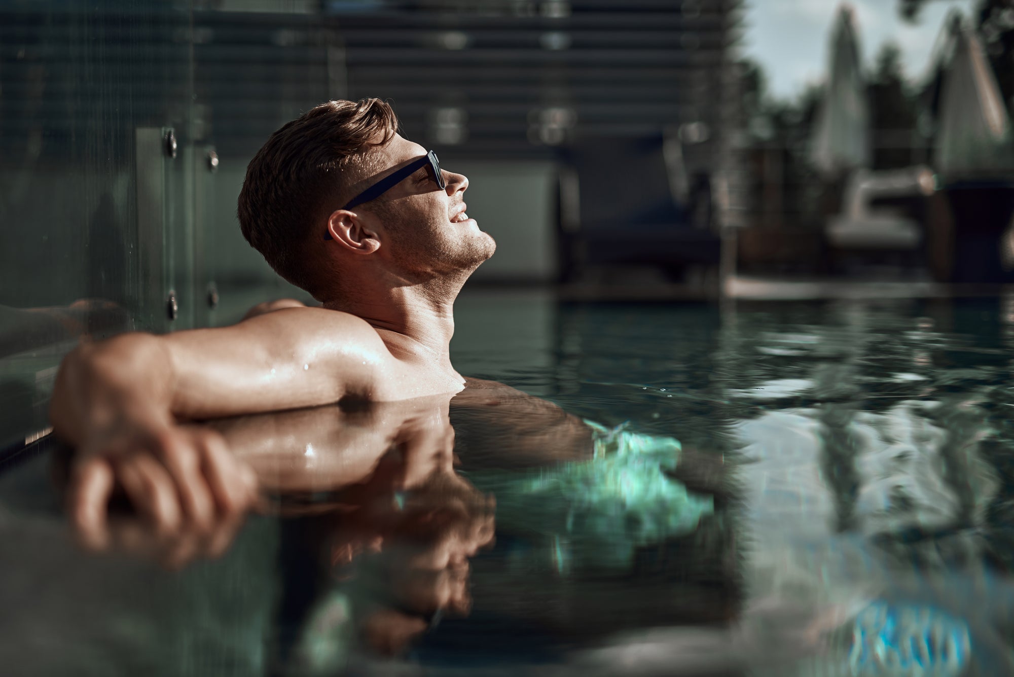 Man relaxing in the pool with sunglasses